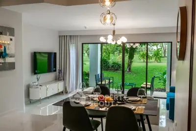 Modern living room with garden view, stylish dining area, and elegant decor in a luxurious home.