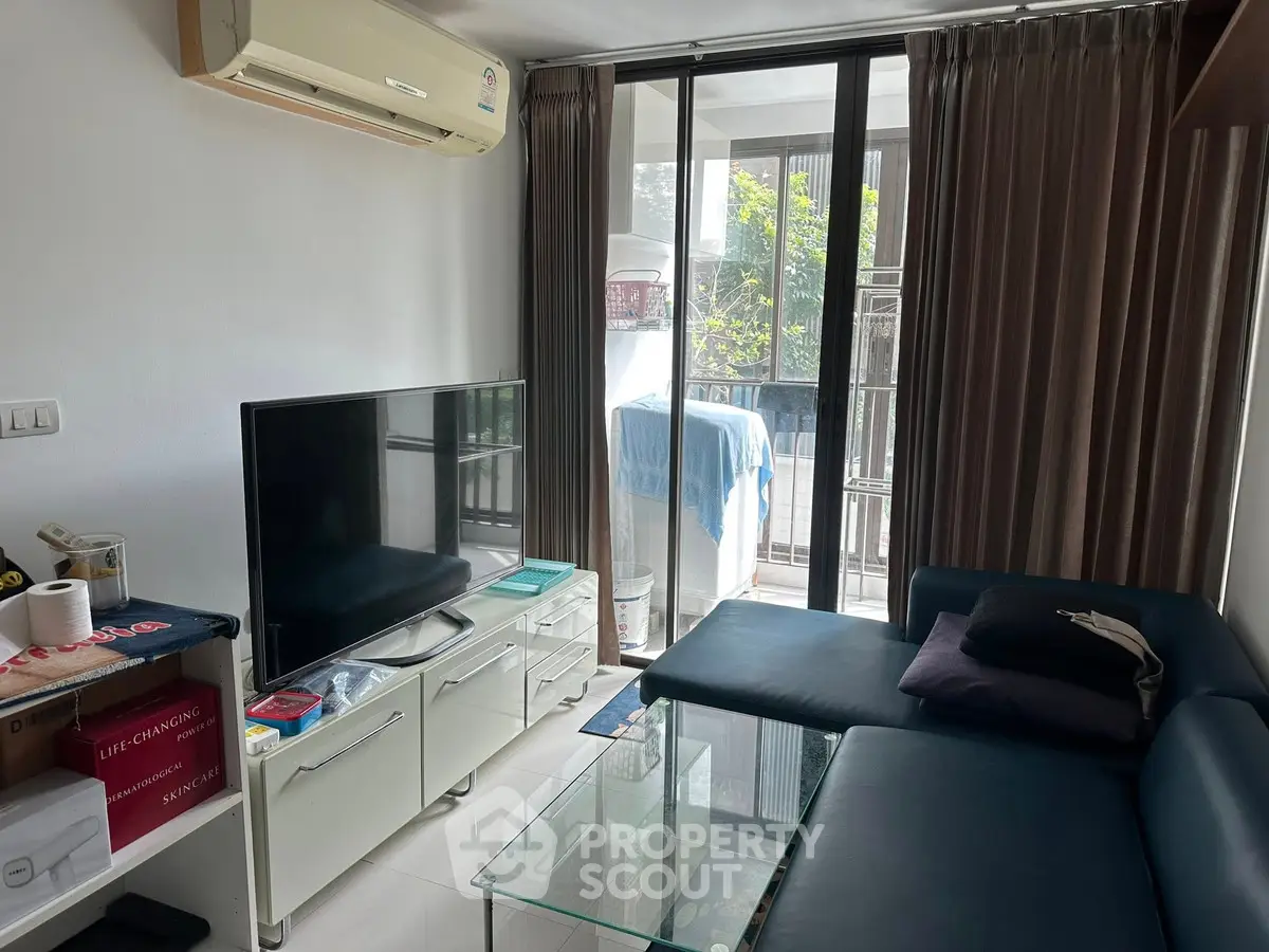 Cozy living room with modern furniture and balcony view, perfect for relaxation and entertainment.