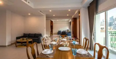 Spacious open-plan living and dining area with elegant furnishings and city view balcony.