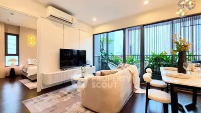 Modern living room with open layout, stylish decor, and large windows overlooking lush greenery.