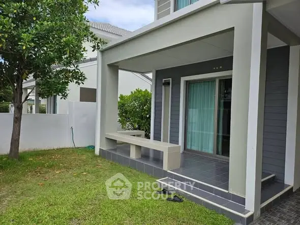 Modern house exterior with patio and lush green lawn