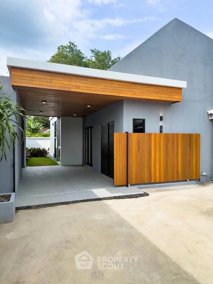 Modern minimalist home exterior with sleek wooden accents and spacious driveway.