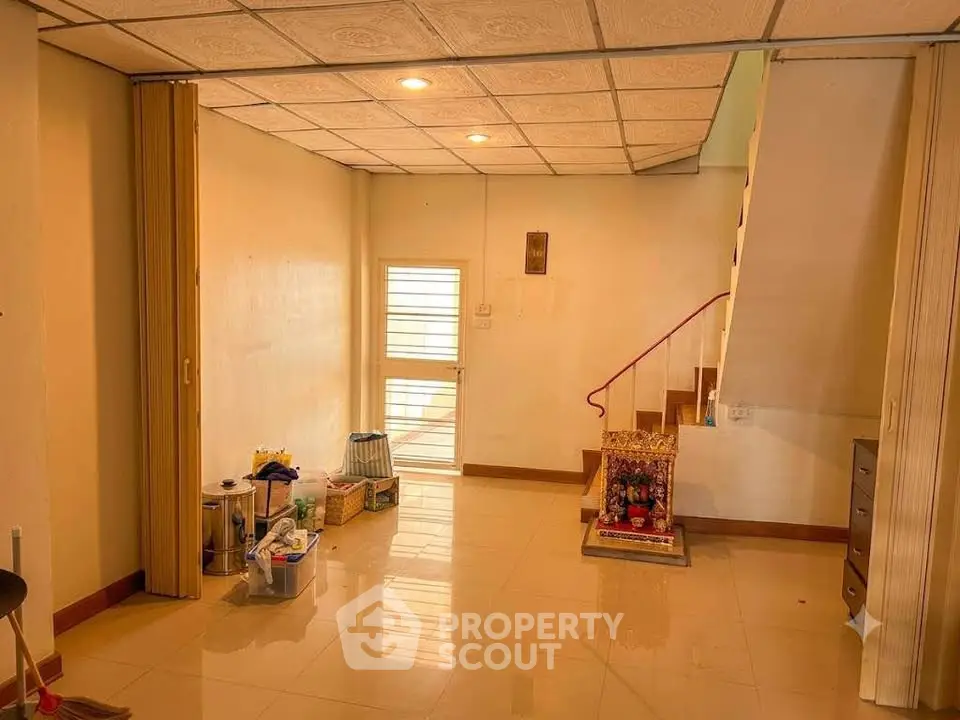 Spacious interior with tiled flooring and staircase, ideal for customization and personal touch.