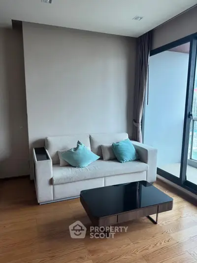 Modern living room with cozy sofa and stylish coffee table near large window with city view.