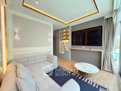 Luxurious living room with modern decor and large TV, perfect for relaxation.