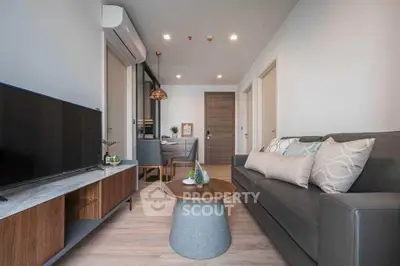 Modern living room with stylish decor and open layout, featuring a sleek TV stand and cozy seating area.