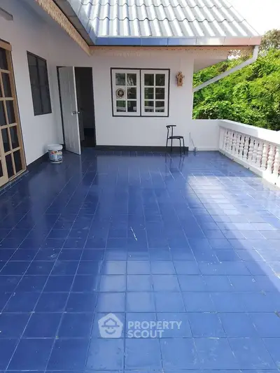 Spacious blue-tiled balcony with scenic views and charming architectural details.