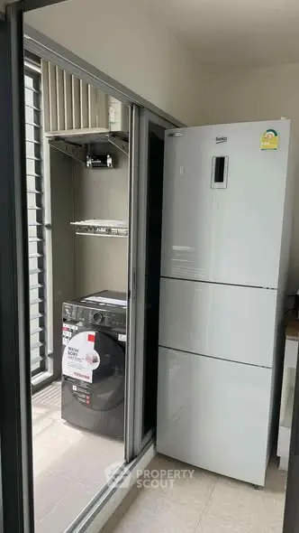 Modern balcony with washing machine and refrigerator, perfect for urban living convenience.