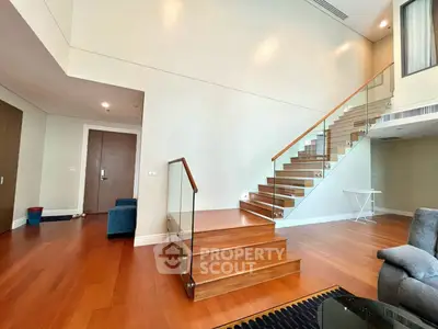 Spacious modern living room with elegant staircase and wooden flooring