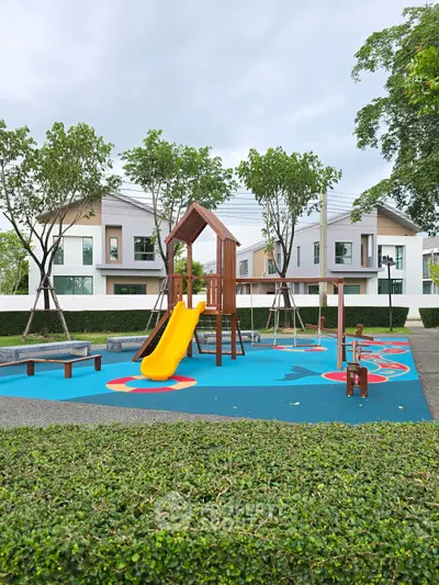 Charming residential playground with modern homes in the background, perfect for family living.
