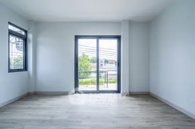 Spacious empty room with large windows and balcony view, perfect for customization.