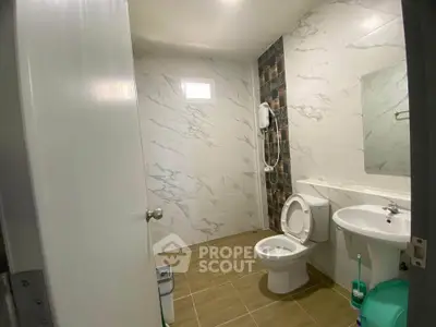 Modern bathroom with marble tiles and shower in a real estate property.