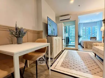 Modern open-plan living room with dining area and view into cozy bedroom