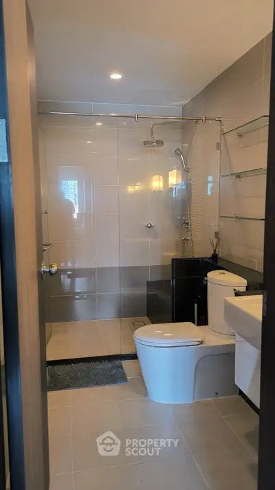 Modern bathroom with glass shower and sleek fixtures in a contemporary apartment.