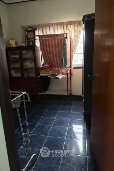 Cozy storage room with tiled floor and ample natural light, perfect for organizing household items.