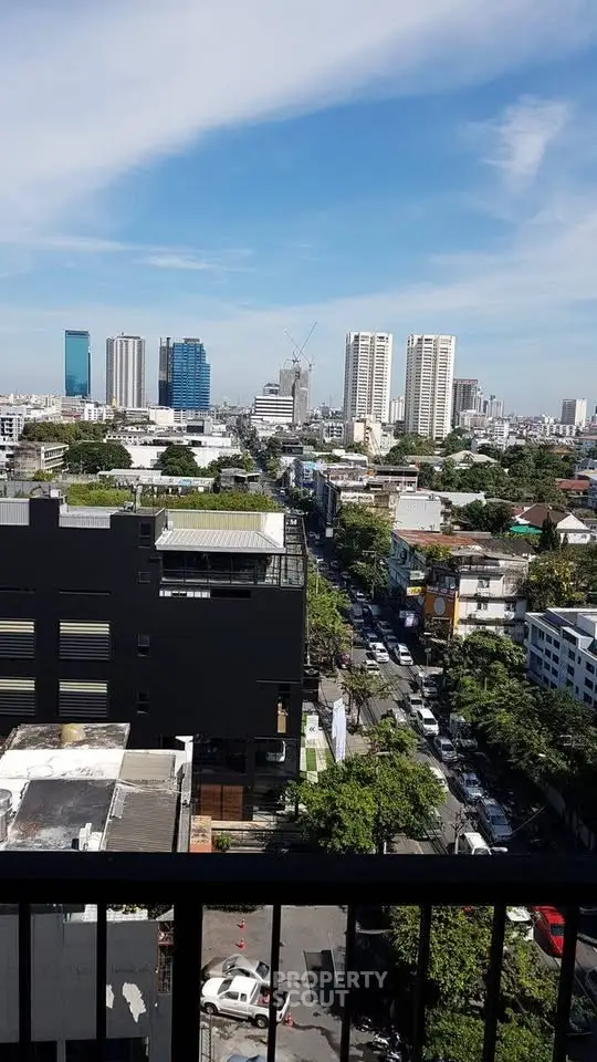 Stunning cityscape view from a high-rise balcony showcasing urban skyline and lush greenery.