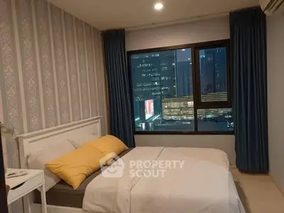 Modern bedroom with city view, featuring stylish wallpaper and cozy bedding.