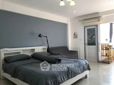Spacious bedroom with modern decor and natural light, featuring a cozy bed and stylish furnishings.