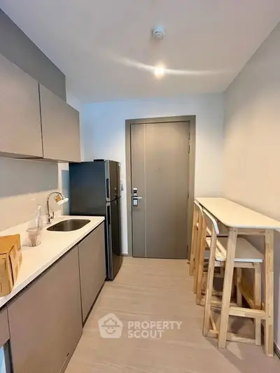 Modern compact kitchen with sleek cabinets and breakfast bar