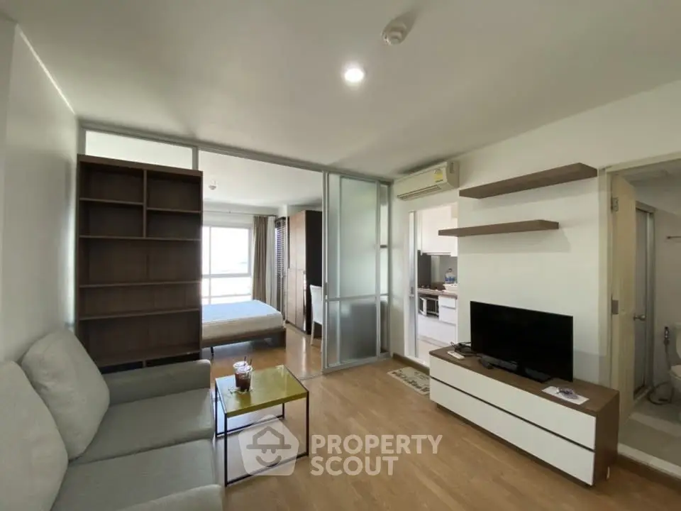 Modern living room with open layout, cozy seating, and sleek TV unit in a stylish apartment.