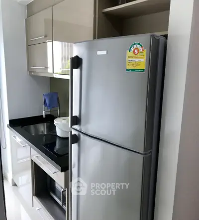 Modern kitchen with sleek appliances and stylish cabinetry in a compact layout.