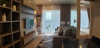 Modern living room with cozy sofa, TV, and large window offering city view in stylish apartment.