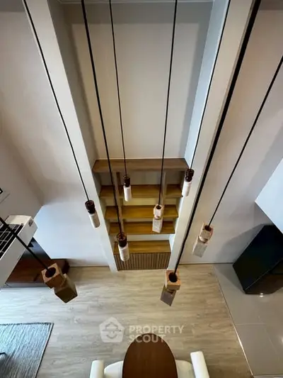 Modern interior with stylish pendant lights and wooden flooring, showcasing a contemporary dining area.