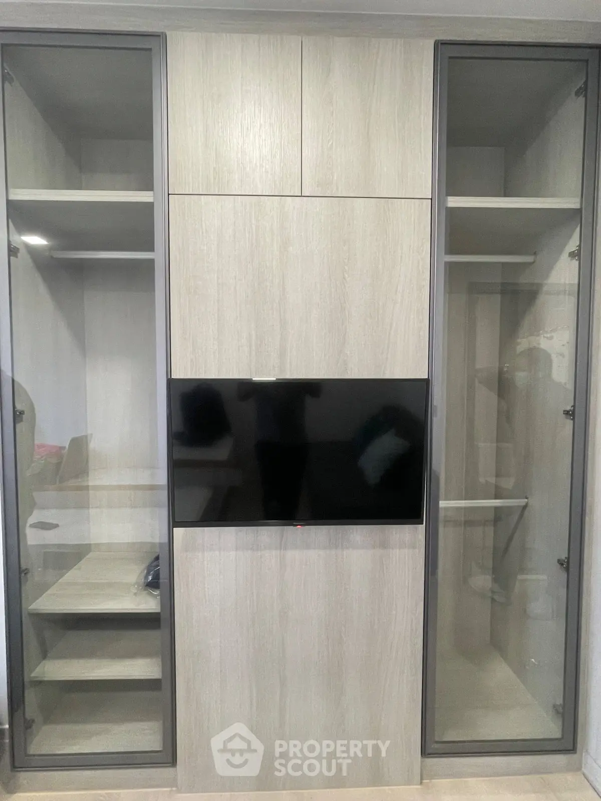 Modern built-in storage unit with glass doors and integrated TV, perfect for stylish living room organization.