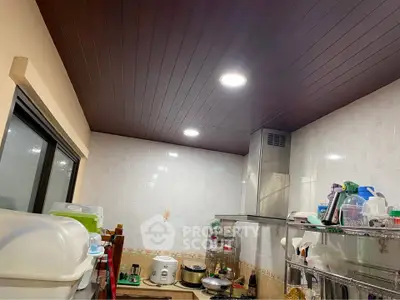 Cozy kitchen with modern appliances and ample storage space, featuring a sleek gas stove and elegant ceiling lights.