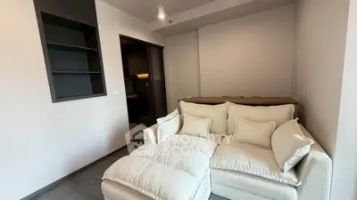 Modern living room with cozy white sofa and built-in shelving, perfect for relaxation.