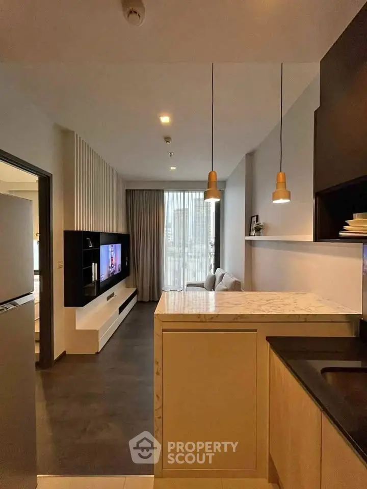 Modern living room with open kitchen and stylish lighting in a contemporary apartment.