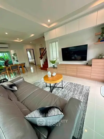 Spacious modern living room with sleek furniture and open layout, perfect for family gatherings.