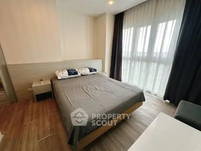 Modern bedroom with large windows and stylish decor in a contemporary apartment.