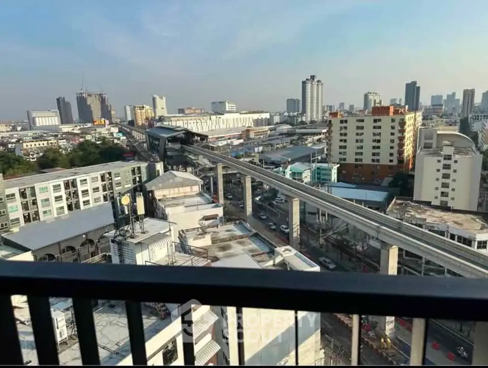 Stunning cityscape view from high-rise balcony with urban skyline and transit lines.