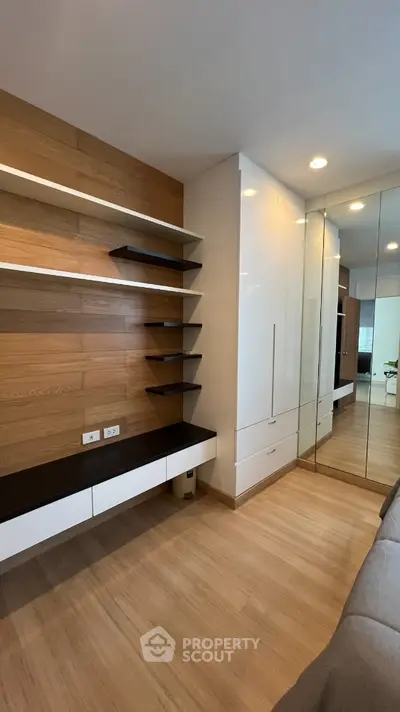 Modern bedroom with sleek built-in storage and mirrored wardrobe