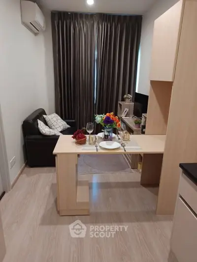 Cozy modern living room with dining area and stylish decor in a compact apartment.