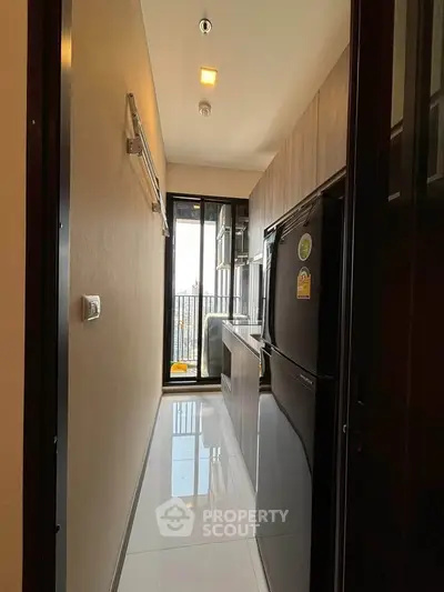 Modern kitchen with sleek appliances and balcony view in a stylish apartment.
