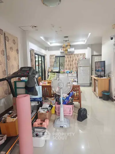 Spacious living room with modern amenities and exercise equipment, perfect for a comfortable lifestyle.