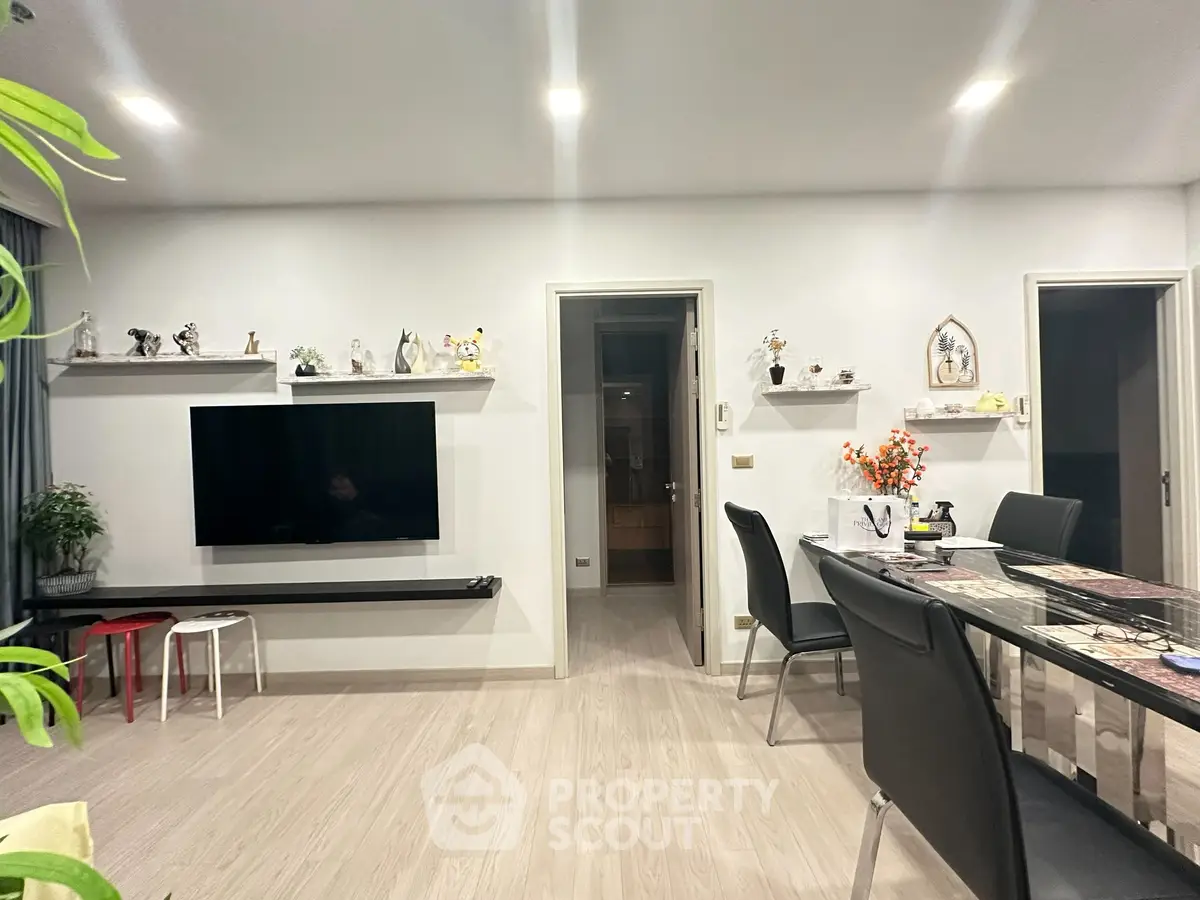 Modern living room with sleek TV setup and elegant dining area, perfect for contemporary living.