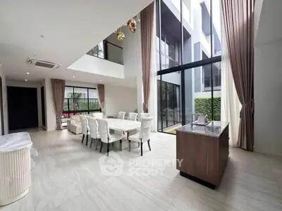 Spacious modern dining area with high ceilings and large windows in luxury home