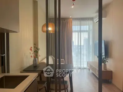 Modern living room with stylish decor and large window offering natural light.
