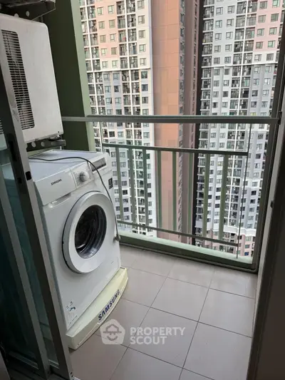 Compact balcony with washing machine and city high-rise view, ideal for urban living convenience.