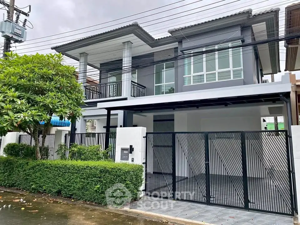 Modern two-story house with sleek design and spacious driveway in a suburban neighborhood.