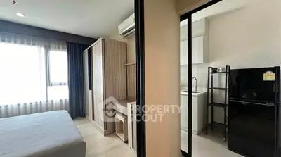 Modern apartment with cozy bedroom and compact kitchen, featuring sleek design and ample natural light.