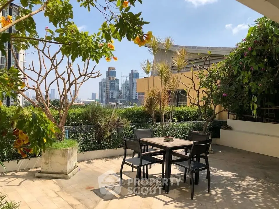 Stunning rooftop terrace with lush greenery and city skyline views, perfect for outdoor dining and relaxation.