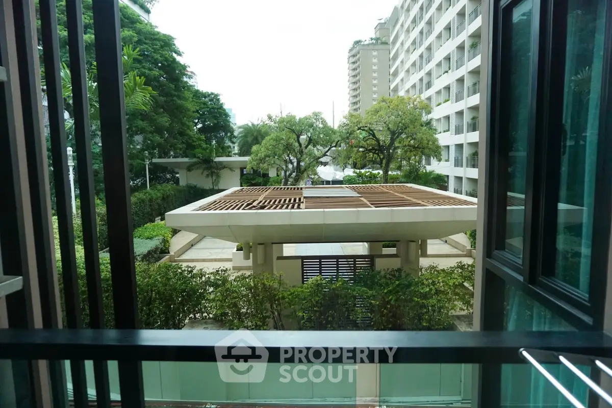 Stunning view from a modern apartment balcony overlooking lush greenery and contemporary architecture.