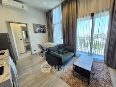 Modern living room with large windows and stylish furniture in a high-rise apartment.