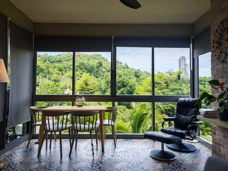 Charming living room with panoramic green views and stylish furniture, perfect for relaxation and entertaining.