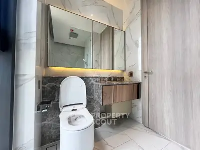 Luxurious modern bathroom with marble tiles and sleek fixtures in a high-end apartment.