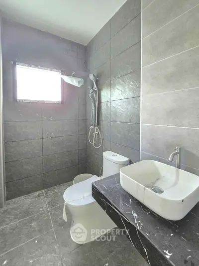 Modern bathroom with sleek gray tiles and contemporary fixtures